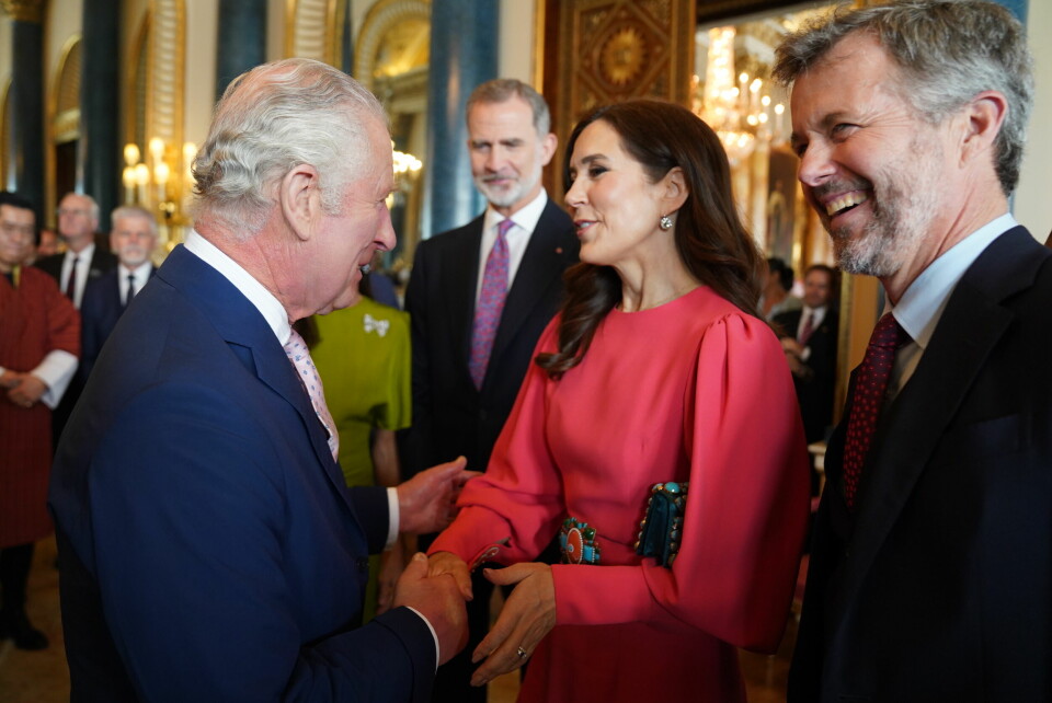 Kronprins Frederik og kronprinsesse Mary taler med Charles dagen før kroningen til en reception på Buckingham Palace i London.