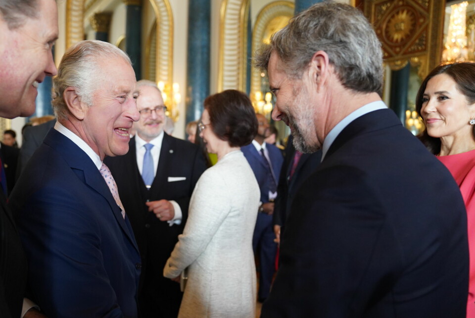 Kronprins Frederik og kronprinsesse Mary taler med Charles dagen før kroningen til en reception på Buckingham Palace i London.