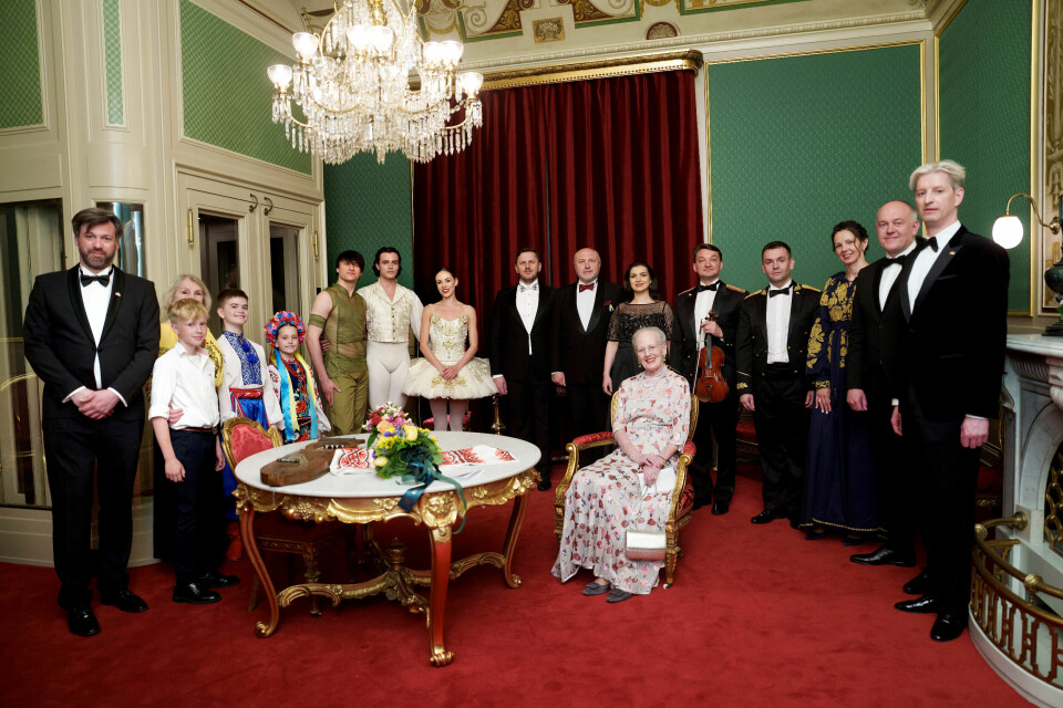Dronningen i kongeværelset omgivet af de medvirkende og yderst til højre det ukrainske ambassadørpar og advokaten Philip Maury, der har taget initiativ til de velgørende forestillinger.