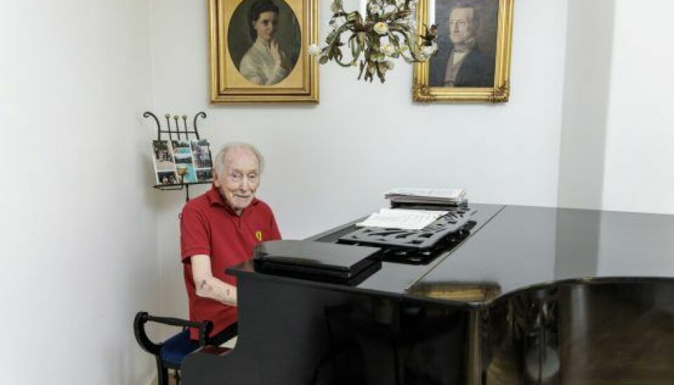 Gregers ved pianoet i stuen med slægtsanerne på væggen. (Foto: Klaus Bo Christensen)