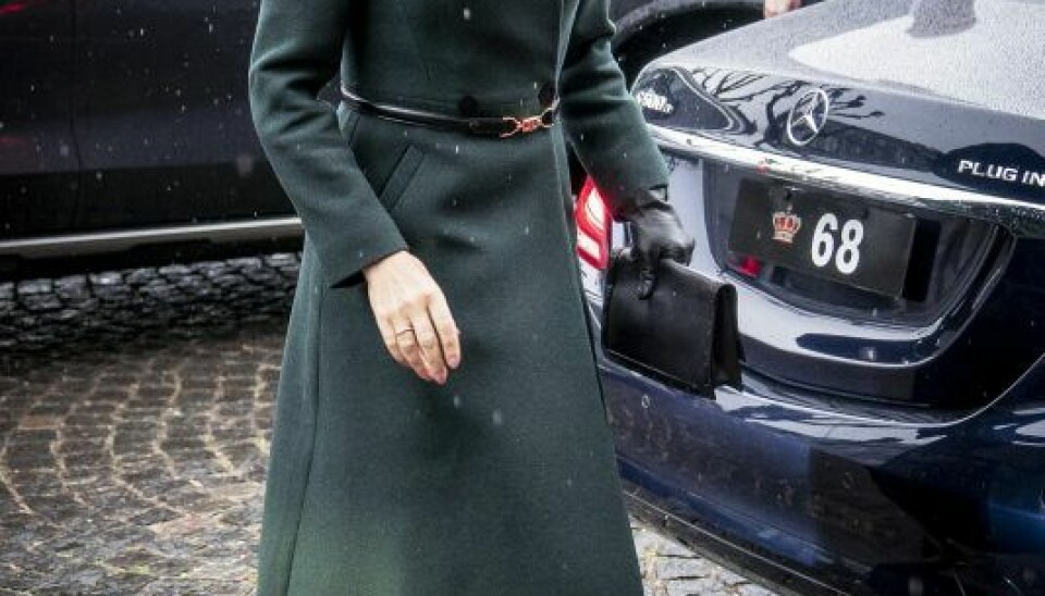 Kronprinsessen var iklædt en smuk, grøn frakke med matchende hat, da hun skyndte sig ind i kirken i ly for regnen. (Foto: Mads Claus Rasmussen/Ritzau Scanpix)